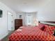 A warm bedroom features a wooden bed frame and matching dresser and nightstand, with a view to the bath at 394 Orange Cosmos Blvd, Davenport, FL 33837