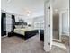 A spacious bedroom with soft carpet, a large bed, and an ensuite bathroom with a walk-in shower at 394 Orange Cosmos Blvd, Davenport, FL 33837