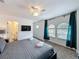 Bright bedroom with arch windows, TV, ceiling fan and ensuite bath at 394 Orange Cosmos Blvd, Davenport, FL 33837