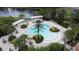 Aerial view of a luxurious community pool area with pergolas, lounge chairs, and lush landscaping at 394 Orange Cosmos Blvd, Davenport, FL 33837