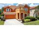 Charming two-story home with a tile roof, a two-car garage, and nicely landscaped front yard at 394 Orange Cosmos Blvd, Davenport, FL 33837