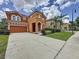 Exterior of home with a spanish tile roof and well-kept landscaping in the front yard at 394 Orange Cosmos Blvd, Davenport, FL 33837