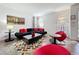 Modern living room features a black sofa with red pillows, contemporary art, and stylish decor at 394 Orange Cosmos Blvd, Davenport, FL 33837