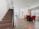 Entryway view leading to a dining area with red chairs and a staircase to the upper level at 394 Orange Cosmos Blvd, Davenport, FL 33837
