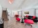 Open-concept living room with neutral tile flooring, modern furniture, and a staircase to the second floor at 394 Orange Cosmos Blvd, Davenport, FL 33837