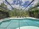 Relax in this stunning screened-in pool with a spa, surrounded by lush greenery and ample space for lounging at 394 Orange Cosmos Blvd, Davenport, FL 33837