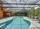 The screened-in pool and spa are perfect for relaxing or entertaining, with lounge chairs and a lush green backdrop at 394 Orange Cosmos Blvd, Davenport, FL 33837