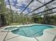 This screened-in pool and spa area features lush landscaping and plenty of room for relaxation at 394 Orange Cosmos Blvd, Davenport, FL 33837