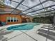 The screened-in pool and spa offer a private oasis with seating, surrounded by lush landscaping and easy access to the home at 394 Orange Cosmos Blvd, Davenport, FL 33837