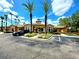 Exterior view of clubhouse featuring well-manicured landscaping, prominent entrance, and ample parking at 5451 Vineland Rd # 111, Orlando, FL 32811
