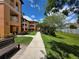 A serene outdoor setting with a wooden bench and manicured lawn leading to the condo buildings at 5451 Vineland Rd # 111, Orlando, FL 32811