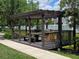 Outdoor grill area perfect for gatherings, featuring picnic tables and a built-in grill at 5451 Vineland Rd # 111, Orlando, FL 32811