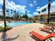 Large community pool with comfortable lounge chairs and well-manicured landscaping at 5451 Vineland Rd # 111, Orlando, FL 32811