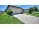 A wide driveway leads to a two-car garage, complemented by lush green grass and manicured shrubs at 5816 Beefmaster Rd, St Cloud, FL 34771