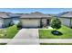 Charming single-story home featuring a well-maintained lawn, two-car garage, and solar panels for energy efficiency at 5816 Beefmaster Rd, St Cloud, FL 34771