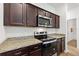 Kitchen features stainless steel appliances, granite countertops, and dark cabinetry at 5816 Beefmaster Rd, St Cloud, FL 34771