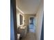 Hallway view of bathroom with granite countertop and framed, lighted mirror at 585 Mourning Dove Cir, Lake Mary, FL 32746