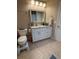 Bathroom with white vanity, granite countertop, framed mirror and tiled flooring at 585 Mourning Dove Cir, Lake Mary, FL 32746