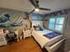 A bedroom featuring laminate flooring, a full bed, a ceiling fan, and a desk setup at 585 Mourning Dove Cir, Lake Mary, FL 32746