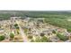 Wide aerial view of a residential community near a wooded area, showcasing diverse home styles and street layouts at 604 Kangaroo Dr, Poinciana, FL 34759