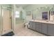 Bright bathroom with dual sinks, a shower, a bathtub, and a decorative mirror with vanity lighting at 604 Kangaroo Dr, Poinciana, FL 34759