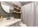 Stylish bathroom with a sink, decorative shelves, dark wood accent wall, and a striped shower curtain at 604 Kangaroo Dr, Poinciana, FL 34759
