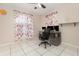 Bright bedroom featuring tile flooring, a ceiling fan, and a desk setup perfect for a home office at 604 Kangaroo Dr, Poinciana, FL 34759