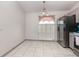 Bright dining area with tile floors, natural light from a window, and a stainless-steel refrigerator at 604 Kangaroo Dr, Poinciana, FL 34759