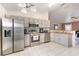 Well-lit kitchen with stainless steel appliances, gray cabinets, tile floors, and a window providing natural light at 604 Kangaroo Dr, Poinciana, FL 34759