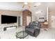 Cozy living room with neutral tones, a ceiling fan, and tile floors that flow into the adjacent kitchen area at 604 Kangaroo Dr, Poinciana, FL 34759