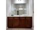 Bathroom vanity with dark wood cabinets, a white countertop, and a large mirror reflecting the shower at 6041 Broad Oak Dr, Davenport, FL 33837