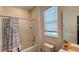 Clean bathroom featuring a shower with a striped curtain and a toilet under a window at 6041 Broad Oak Dr, Davenport, FL 33837