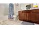 This bathroom features a wood vanity and a shower and tub combination with an ocean-themed shower curtain at 6041 Broad Oak Dr, Davenport, FL 33837