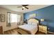 Cozy bedroom with ceiling fan, a blue accent wall, and natural light from the window at 6041 Broad Oak Dr, Davenport, FL 33837