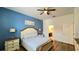 Bedroom featuring a queen bed, a blue accent wall, and bright bedside lamps at 6041 Broad Oak Dr, Davenport, FL 33837