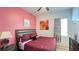 Vibrant bedroom with pink accent wall, dark wood furnishings, and a plush queen bed at 6041 Broad Oak Dr, Davenport, FL 33837