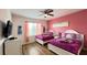 bedroom with two beds, pink walls, and a large window providing natural light at 6041 Broad Oak Dr, Davenport, FL 33837