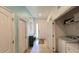 Bright hallway featuring tile flooring, a laundry area, and access to the front entrance at 6041 Broad Oak Dr, Davenport, FL 33837