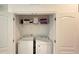 Laundry closet with washer, dryer, storage shelf, iron and folded towels at 6041 Broad Oak Dr, Davenport, FL 33837