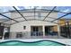 View of the backyard featuring a screened-in pool, hot tub, covered patio, and grilling area at 6041 Broad Oak Dr, Davenport, FL 33837