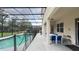 Relaxing pool area with covered patio, dining set, safety fence, and black metal pool enclosure at 6041 Broad Oak Dr, Davenport, FL 33837