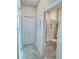 Hallway view of a clean and bright bathroom with a glass-enclosed shower and tiled floors at 703 Ocean Course Ave, Davenport, FL 33896