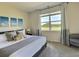 Well-lit bedroom with a plush bed, stylish artwork, and a large window showcasing a scenic view at 703 Ocean Course Ave, Davenport, FL 33896