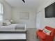 Clean bedroom with a trundle bed, a mounted TV, closet space and an orange accent chair with decorative pillow at 703 Ocean Course Ave, Davenport, FL 33896