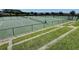 Community tennis courts with a perimeter fence and well maintained grass at 703 Ocean Course Ave, Davenport, FL 33896