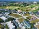 Wide aerial view of a vibrant residential area featuring a golf course and residential buildings with lush trees at 7503 Mourning Dove Cir # 101, Reunion, FL 34747