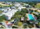 Aerial view of condo buildings, swimming pool, surrounding manicured landscaping, and nearby roads in a residential area at 7503 Mourning Dove Cir # 101, Reunion, FL 34747