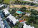 Aerial view of a residential community featuring condo buildings, a swimming pool, lush landscaping, and surrounding properties at 7503 Mourning Dove Cir # 101, Reunion, FL 34747