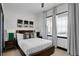 Bright bedroom features a wood-trimmed bed frame, modern decor, and streams of natural light through two windows at 7503 Mourning Dove Cir # 101, Reunion, FL 34747