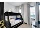 Comfortable bedroom with a black bunk bed and large windows providing natural light at 7503 Mourning Dove Cir # 101, Reunion, FL 34747